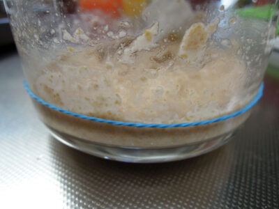オレンジ色のにんじん酵母エキスと全粒粉を混ぜ、中種を仕込む