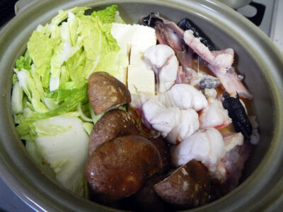 あんこうの肝を炒めてつくったスープや下処理した身とあら、野菜などを鍋に入れる